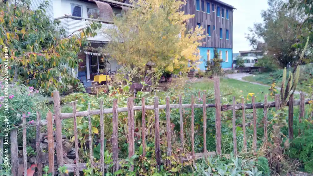 Über den Gartenzaun fotografiert: ein Gemeinschaftshaus auf Schloss Tempelhof.