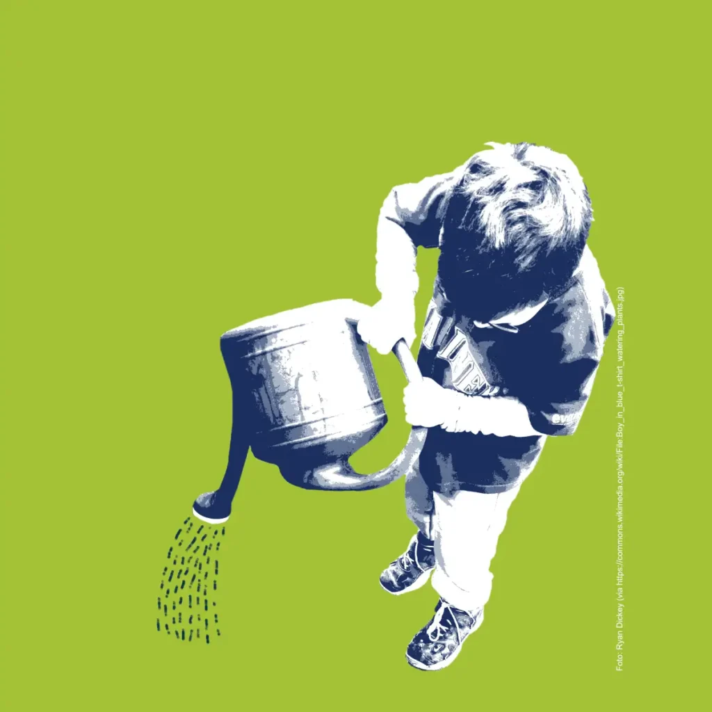 Ein kleiner Junge gießt mit einer Gießkanne